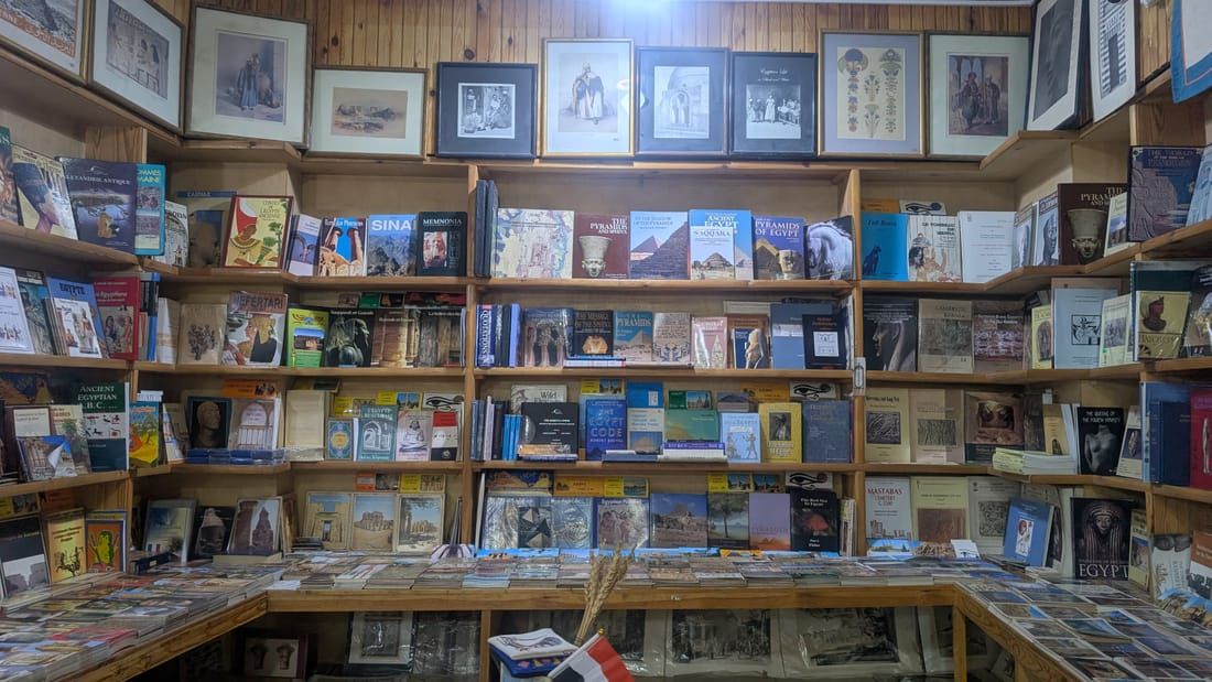 Interior of Aboudi Bookstore on Luxor's East Bank, with books and prints covering the shelves and walls.
